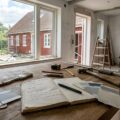 Budgetplanlægning til renovering af hus med værktøj og tegninger på bord